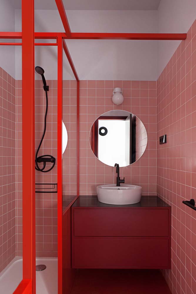 Aqui, a cor branca da pia para banheiro pequeno ajuda a destacar o móvel vermelho