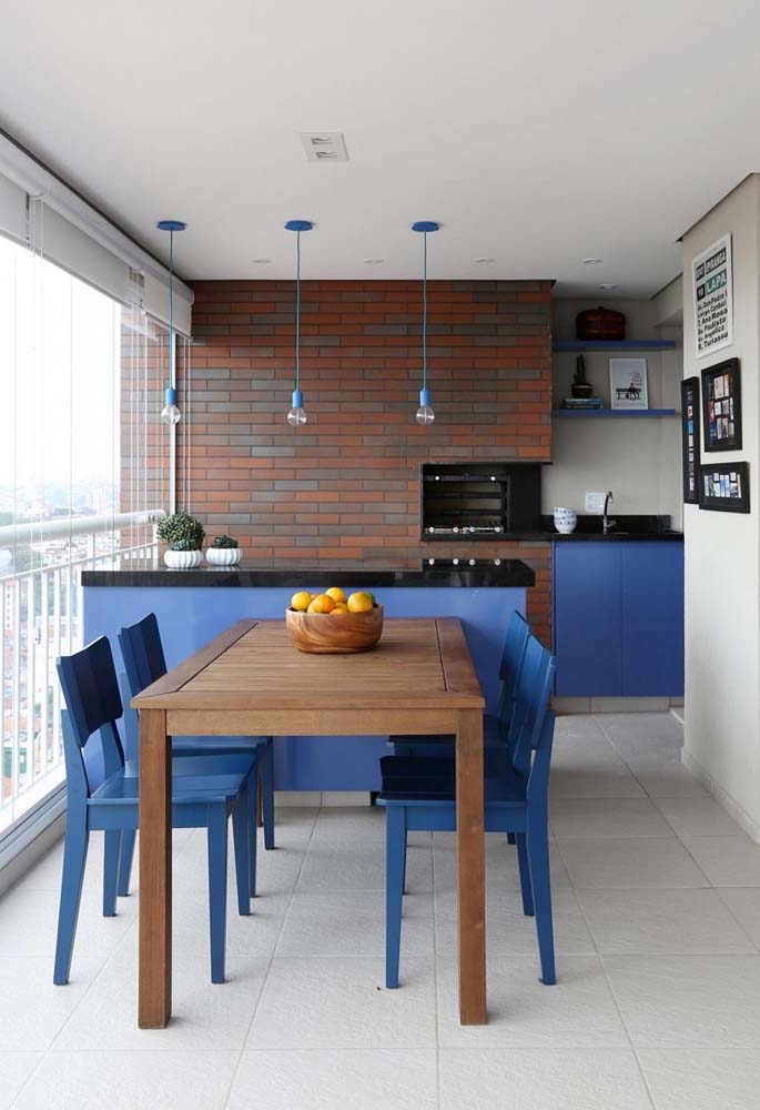 Varanda gourmet com churrasqueira moderna decorada em tons de azul, preto, branco e marrom