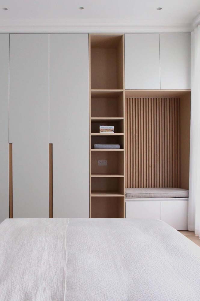 Um belíssimo armário planejado para quarto de casal com espaço dedicado para nichos.