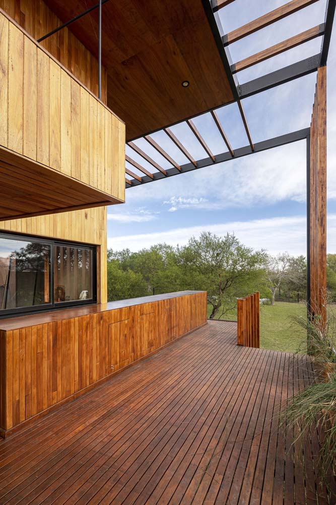 Casa de campo com pergolado de madeira em estrutura metálica.