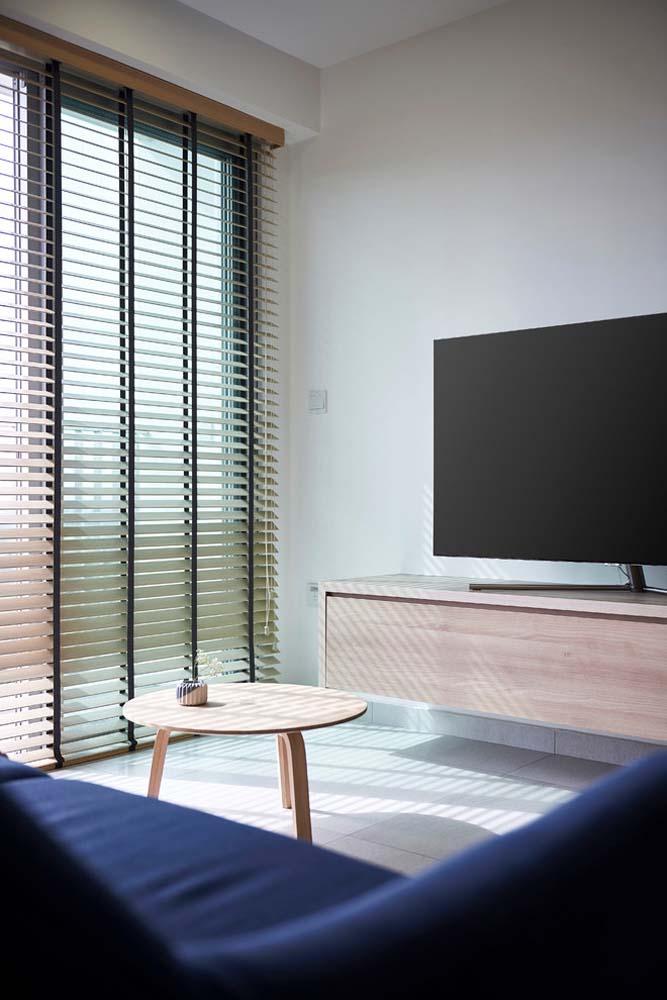 Sala de TV pequena com persiana de madeira horizontal para garantir privacidade nos momentos necessários.