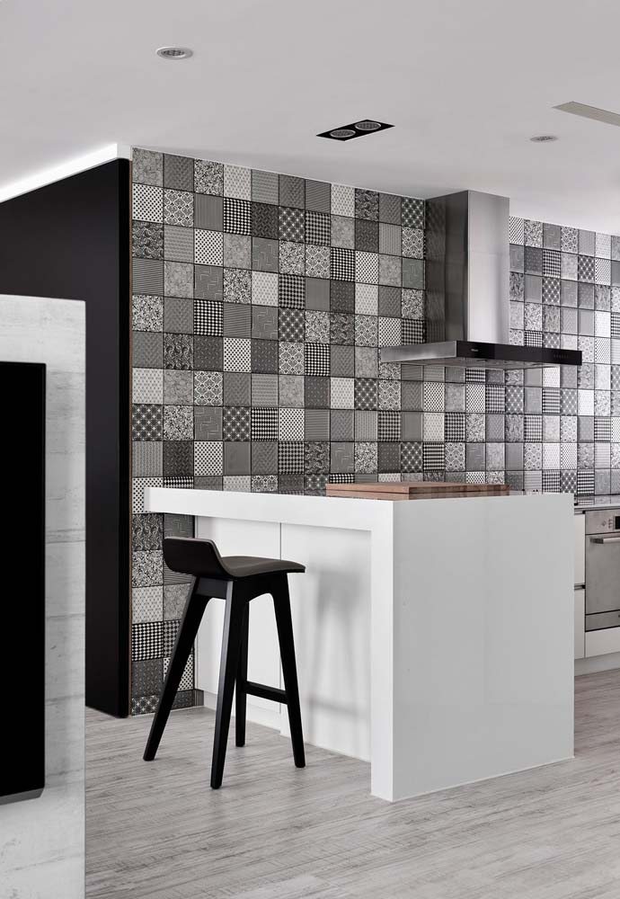 Decoração de cozinha compacta em L com revestimento cinza na parede.