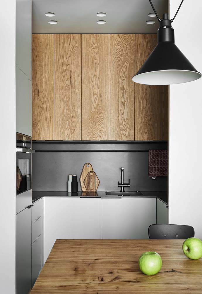 Cozinha compacta e super moderna com pé direito alto, cinza e madeira.