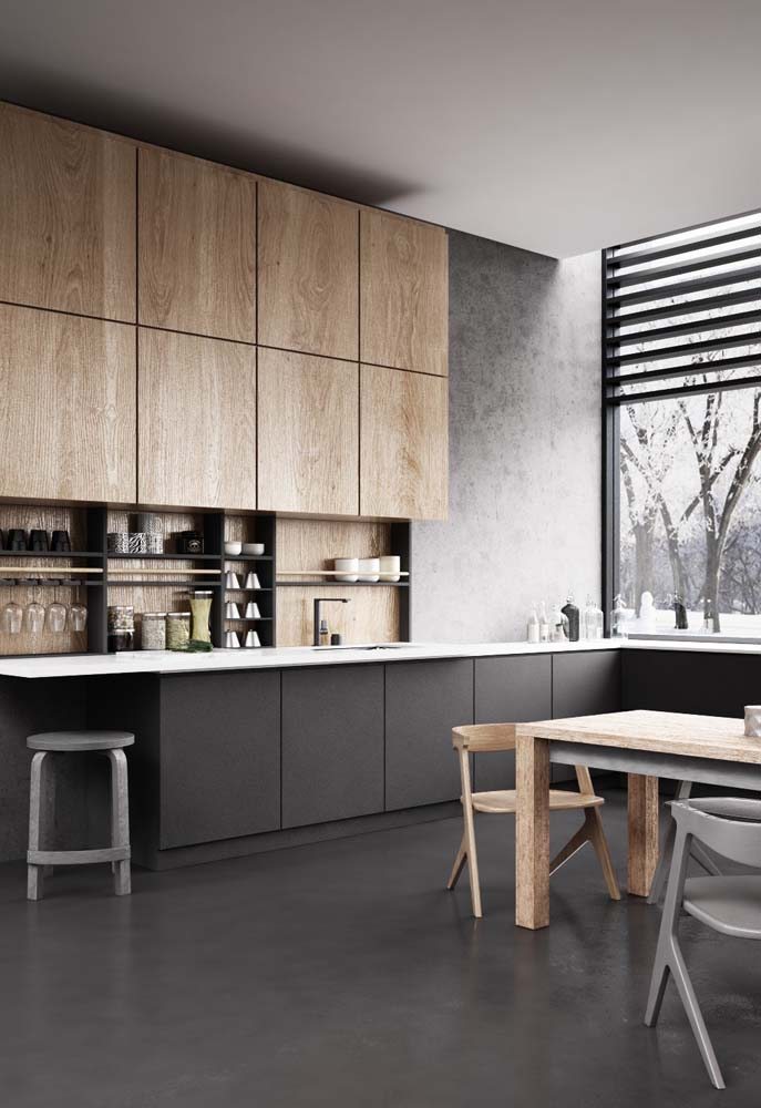 Cozinha ampla em L com bancada de pedra branca, armários inferiores na cor preta e superiores na cor madeira.