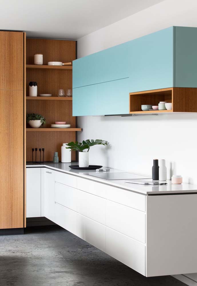 Cozinha em L com armário branco na parte inferior e armário azul claro na parte superior.