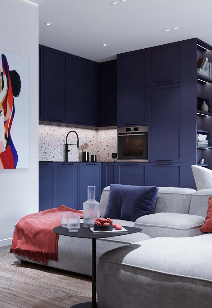 Cozinha em L com granilite e armário azul.