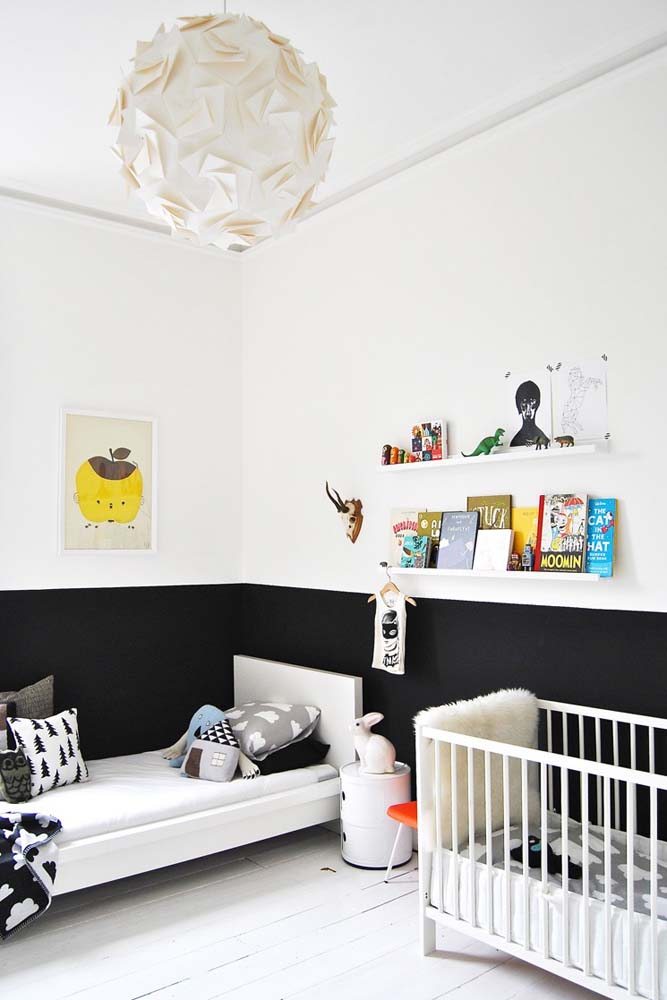 Até o quarto de bebê pode ter este estilo decorativo: aqui com meia parede pintada de preto e amplo foco na cor branca nos móveis e objetos.