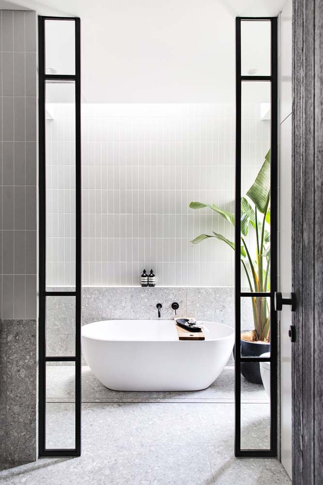 Banheiro minimalista e com amplo espaço com banheira branca.