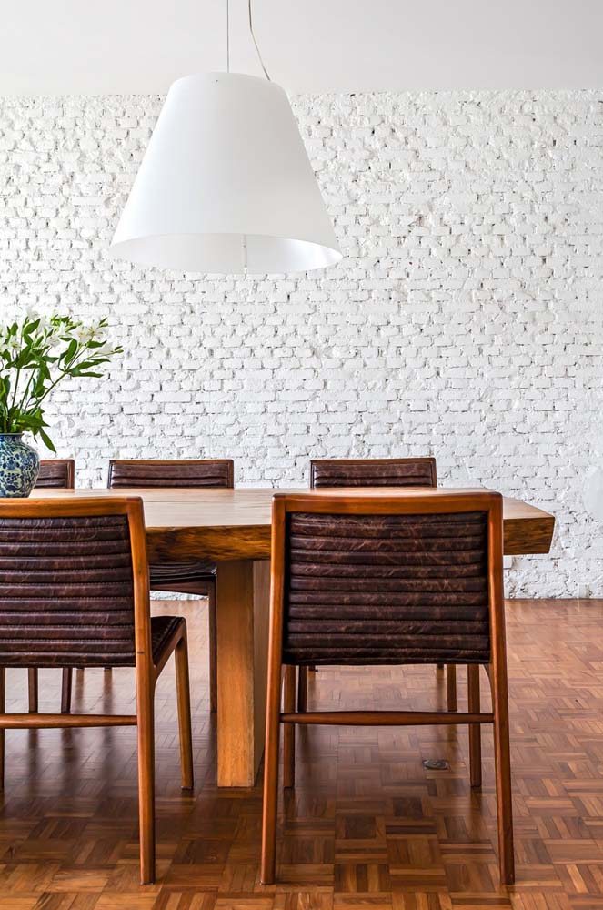 Parede de tijolos e piso de tacos: mesmo com a mesa rústica o estilo ainda pode ser minimalista.
