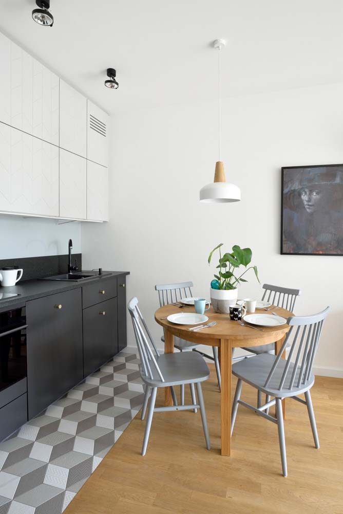 Mini cozinha minimalista com mesa de jantar redonda de madeira.