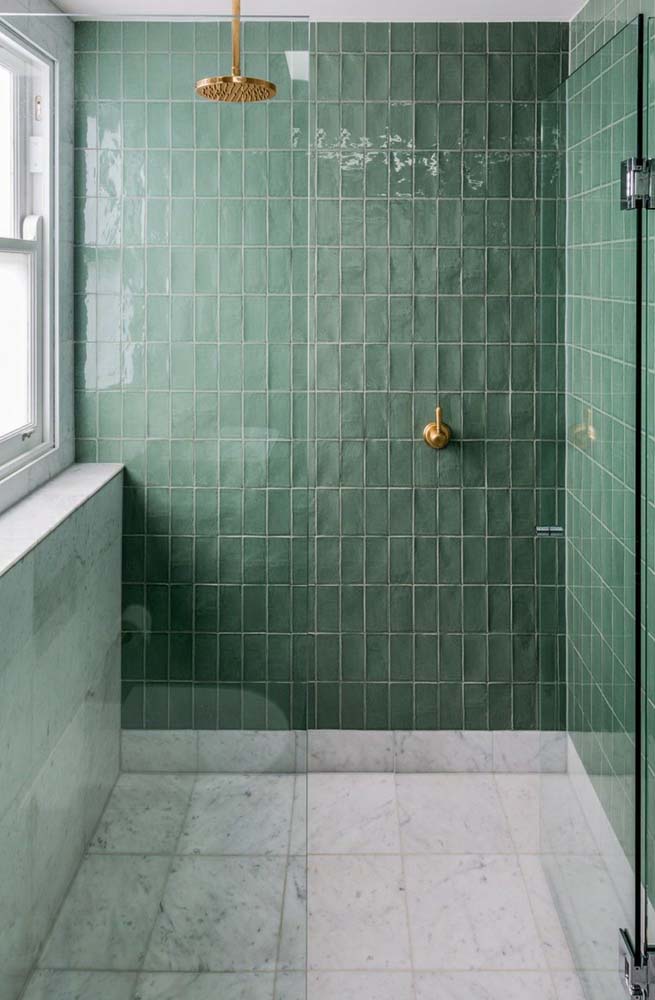 Revestimento verde água no banheiro. O charme a mais fica por conta do chuveiro dourado