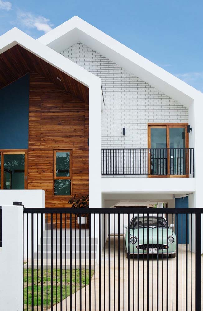 Moderna e aconchegante, essa fachada de casa simples com varanda está integrada com a garagem