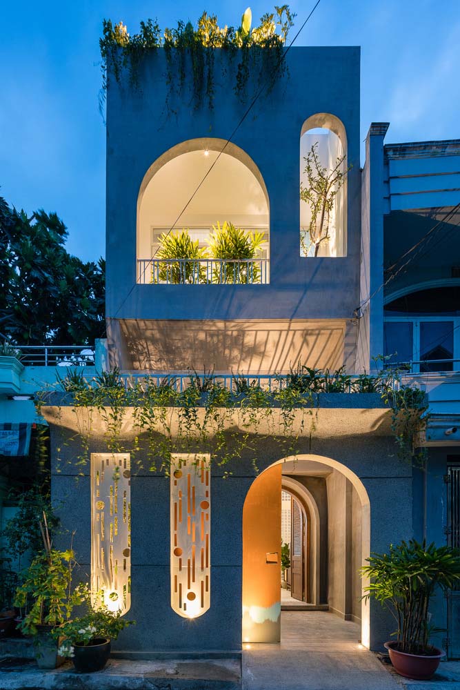A iluminação é o destaque dessa fachada de casa simples com varanda na frente