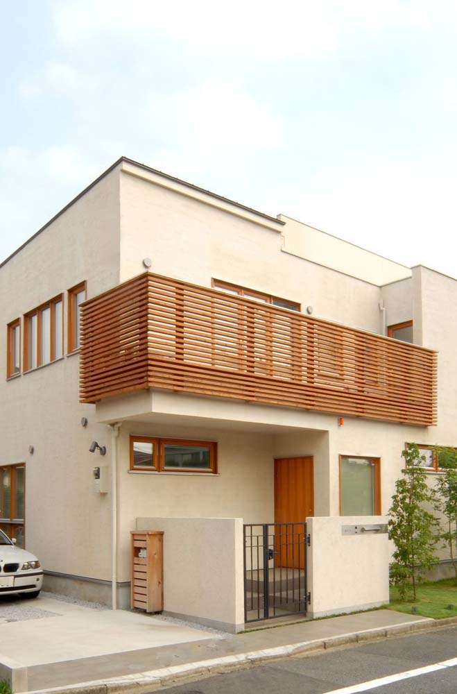 Que tal uma fachada de casa simples com varanda em madeira?