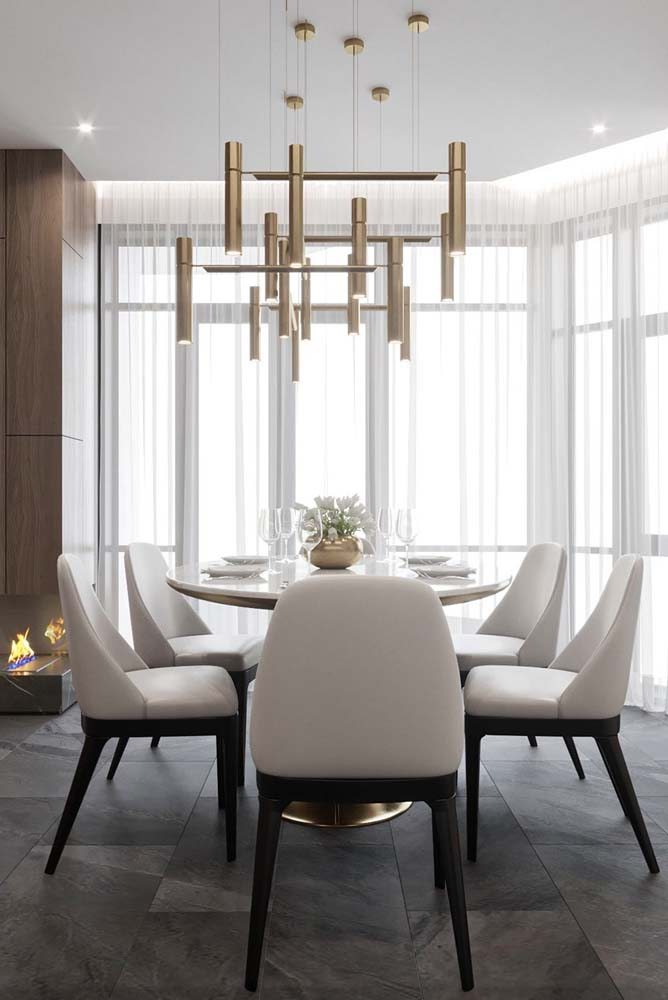 Mesa branca e redonda com 6 cadeiras para sala de jantar elegante.