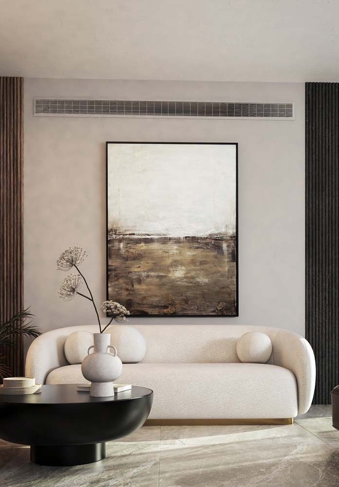 Sala com cores neutras recebe quadro abstrato com moldura preta.