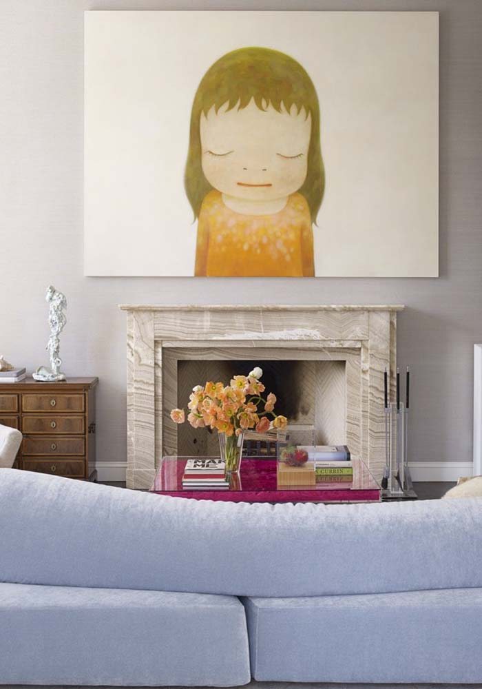 Sala de estar com lareira e grande quadro com personagem ilustrado.