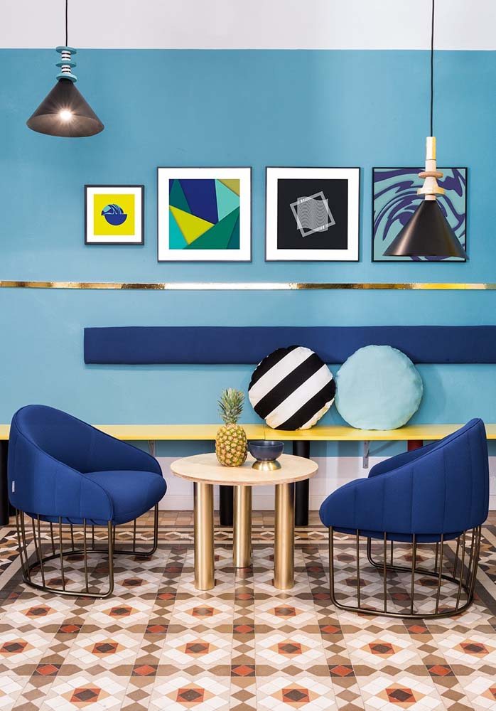 Ambiente com diferentes tons de azul e quarteto de quadros decorativos pequenos.