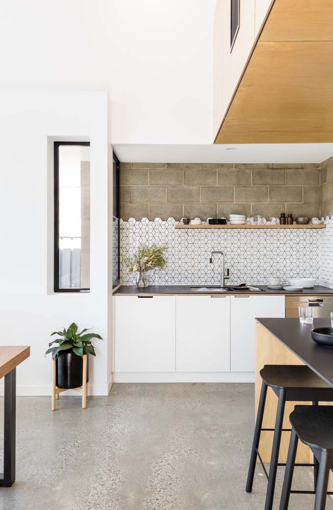 Uma cozinha pequena com janela, mas que é muito funcional para os ambientes integrados
