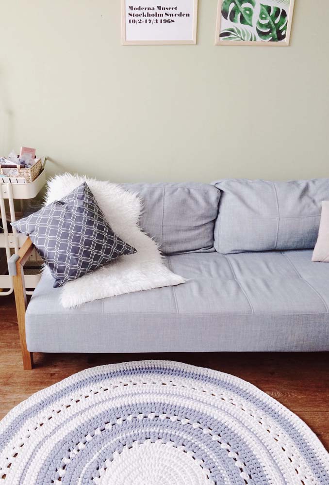 Um tapete de crochê redondo para sala seguindo a mesma cor do sofá