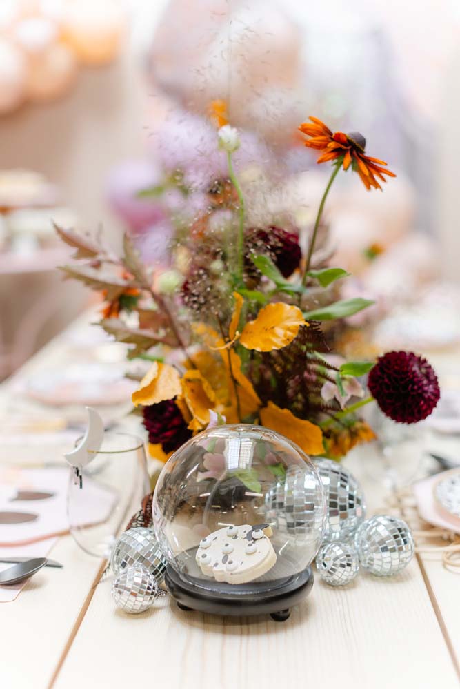 As flores da mesa acompanham a paleta de cores tradicional do halloween