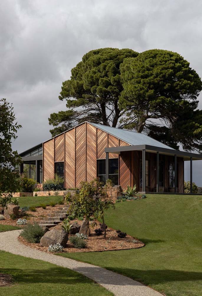 Já esta casa de madeira conta com projeto de paisagismo personalizado.