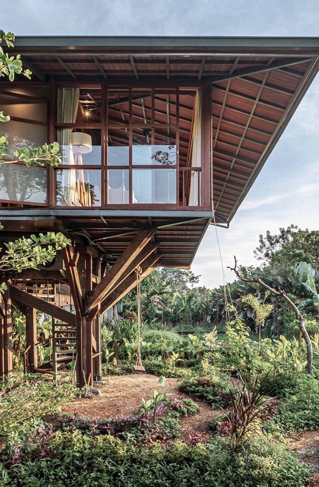 Casa de madeira suspensa com pavimento elevado para aproveitar toda a vista da natureza.