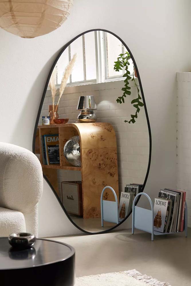 Fuja dos formatos retangulares tradicionais e aposte em um espelho curvo para decorar o seu ambiente.