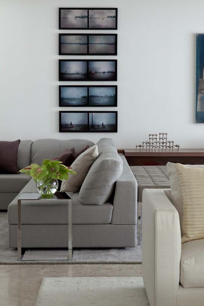Modelo de sofá cinza de canto de tecido para sala de estar ampla.