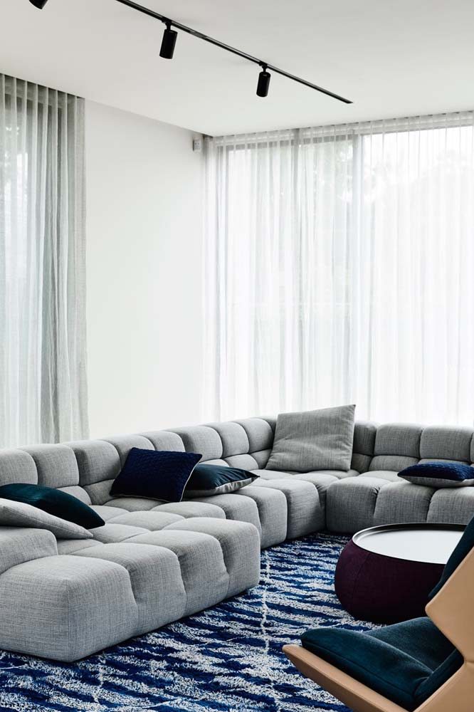 Modelo de sofá de canto de tecido cinza grande com almofadas.