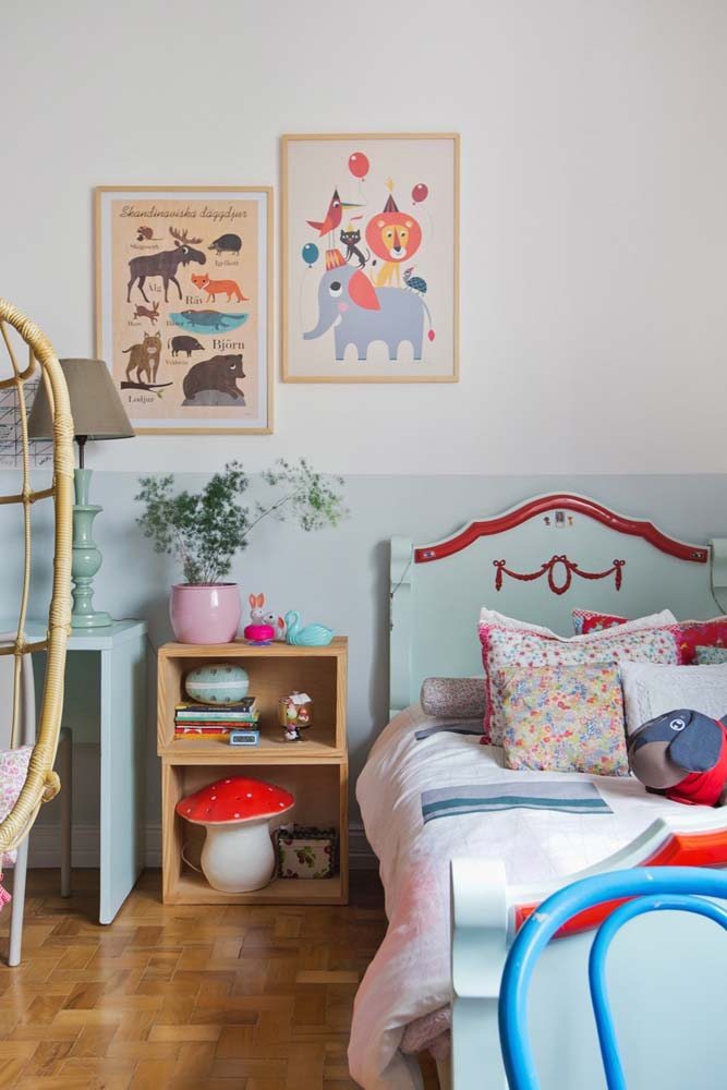 Lindo quarto infantil com cama de madeira em pintura verde água, acompanhando a pintura da parede.