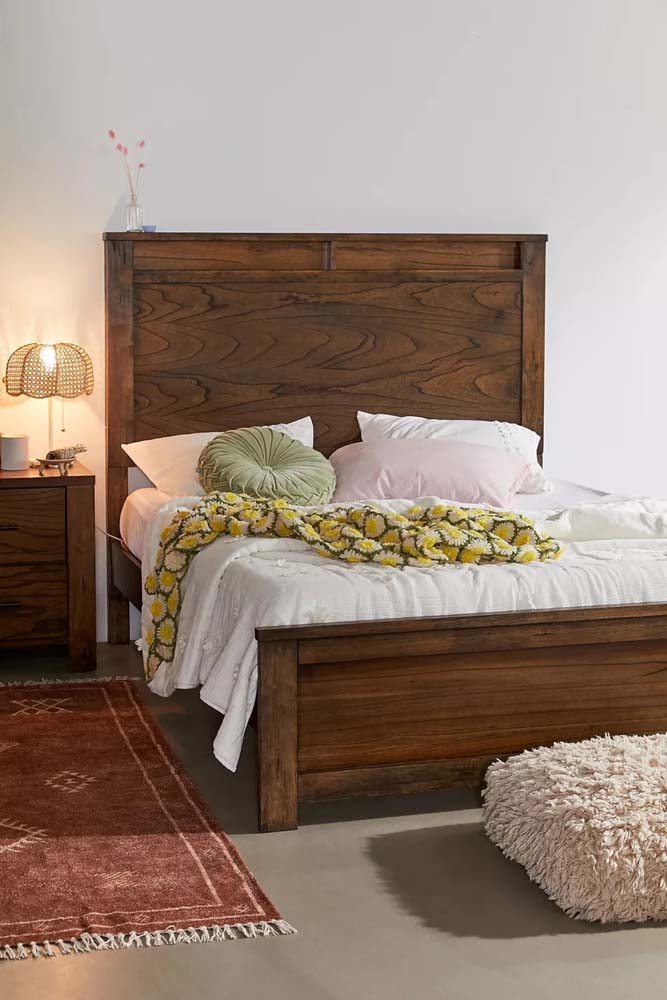 Modelo de cama de madeira maciça em combinação com cômoda seguindo o mesmo material.