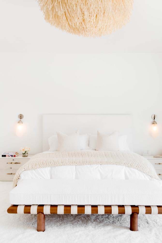 Decoração de quarto com estilo escandinavo, com ampla presença da cor branca e cama minimalista baixa com cabeceira.