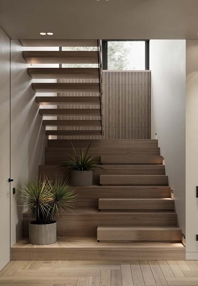 Modelo de escada em U minimalista com revestimento de madeira lara e espaço para vasos.