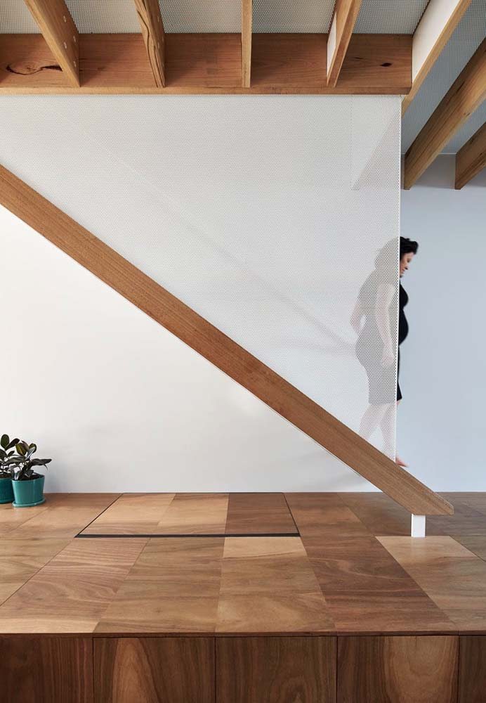 Escada de madeira simples e minimalista com proteção lateral.
