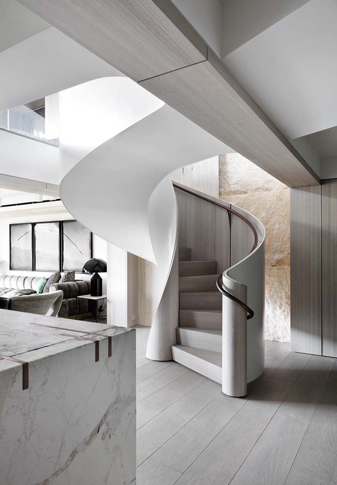 Escada de design curvo personaliazdo para residência luxuosa com dois pavimentos.