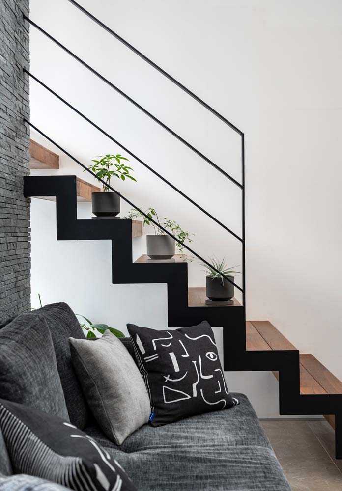Combinação de escada metálica com pintura preta e degraus com madeira.