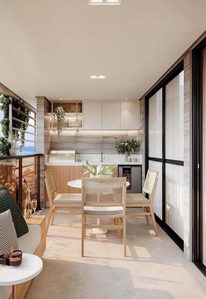 A integração da varanda gourmet com os ambientes internos ajuda o apartamento a parecer maior