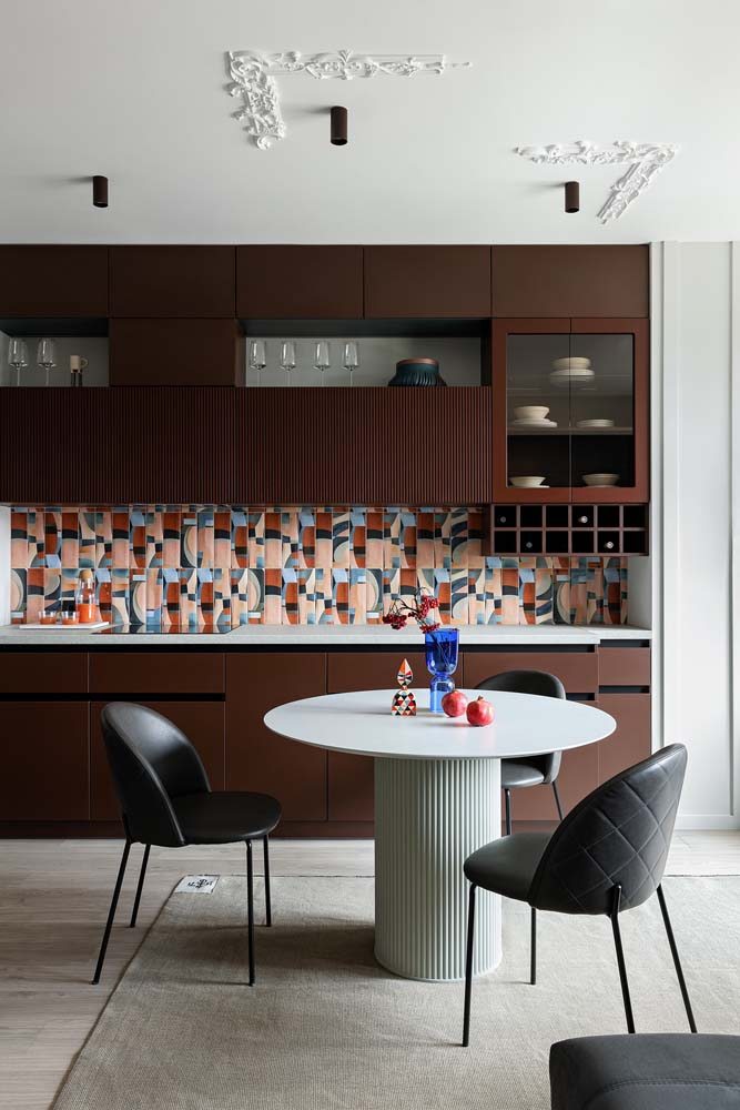 Cozinha moderna planejada marrom com revestimento colorido artístico de azulejo na altura da bancada.