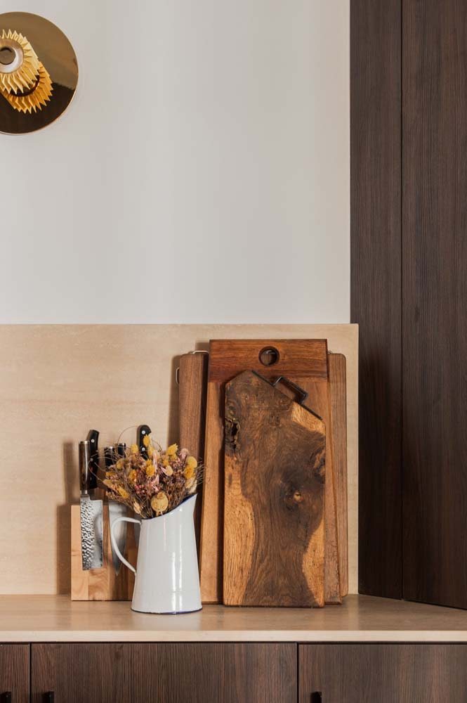 Modelo armário planejado marrom com pedra clara na cozinha e pintura branca nas paredes.</