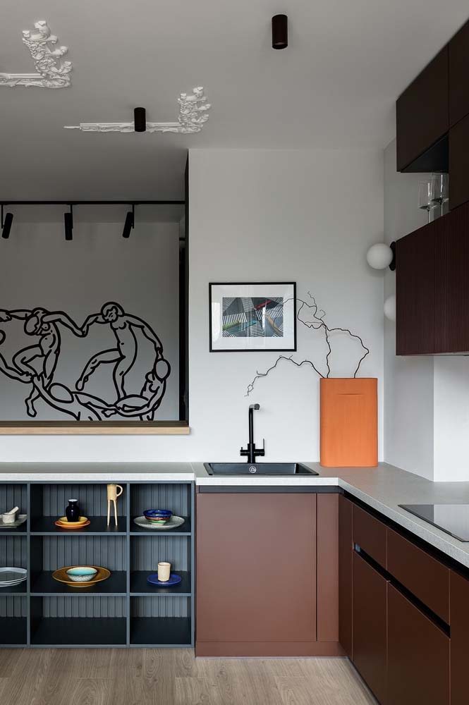 Cozinha com portas de armários na cor marrom e bancada com revestimento moderno em cor clara.