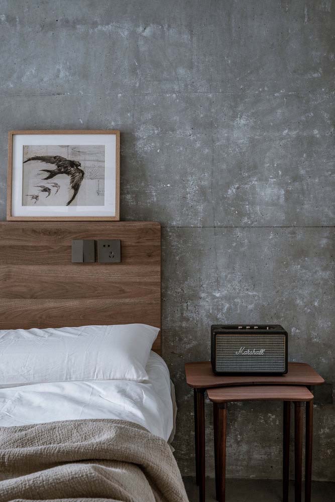 Lindo quarto industrial com um toque rústico da madeira e parede de concreto aparente
