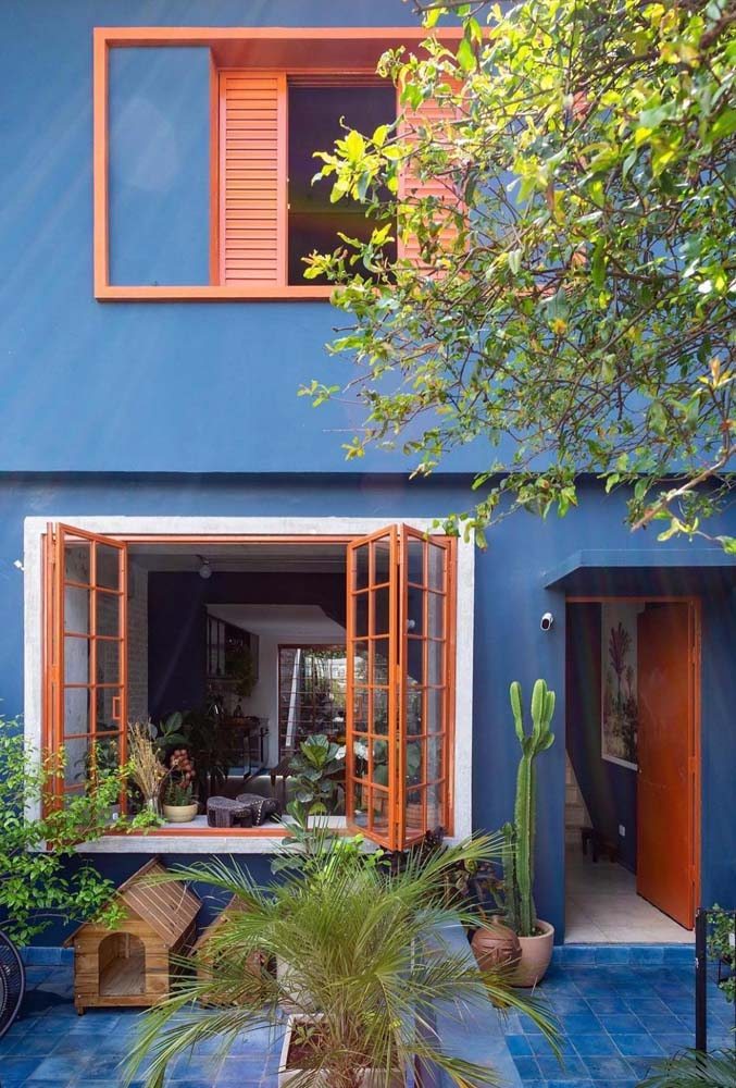 Azul e laranja, cores complementares, para trazer alegria e descontração para fachada de casa simples
