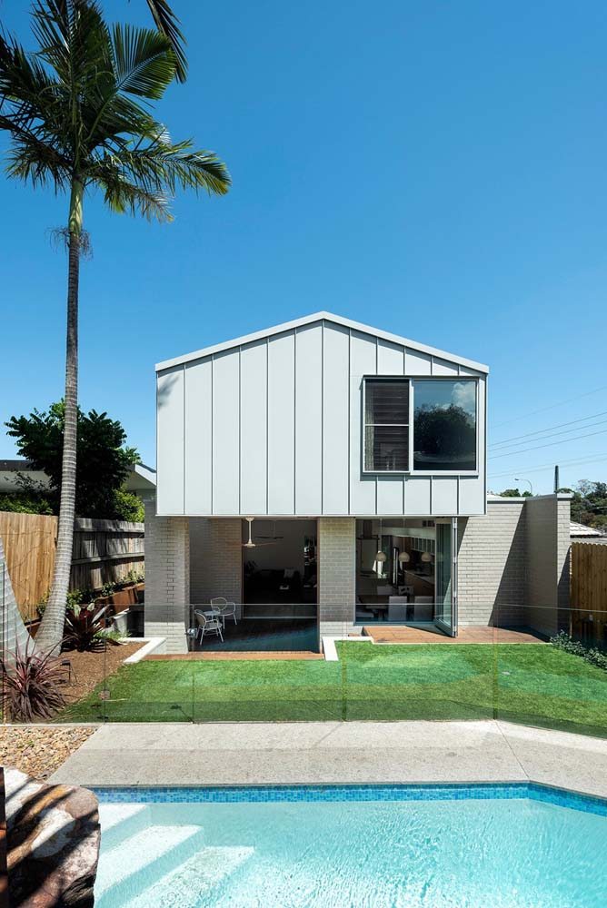 Fachada de casa simples e moderna em cores claras e neutras que ajudam a valorizar o quintal
