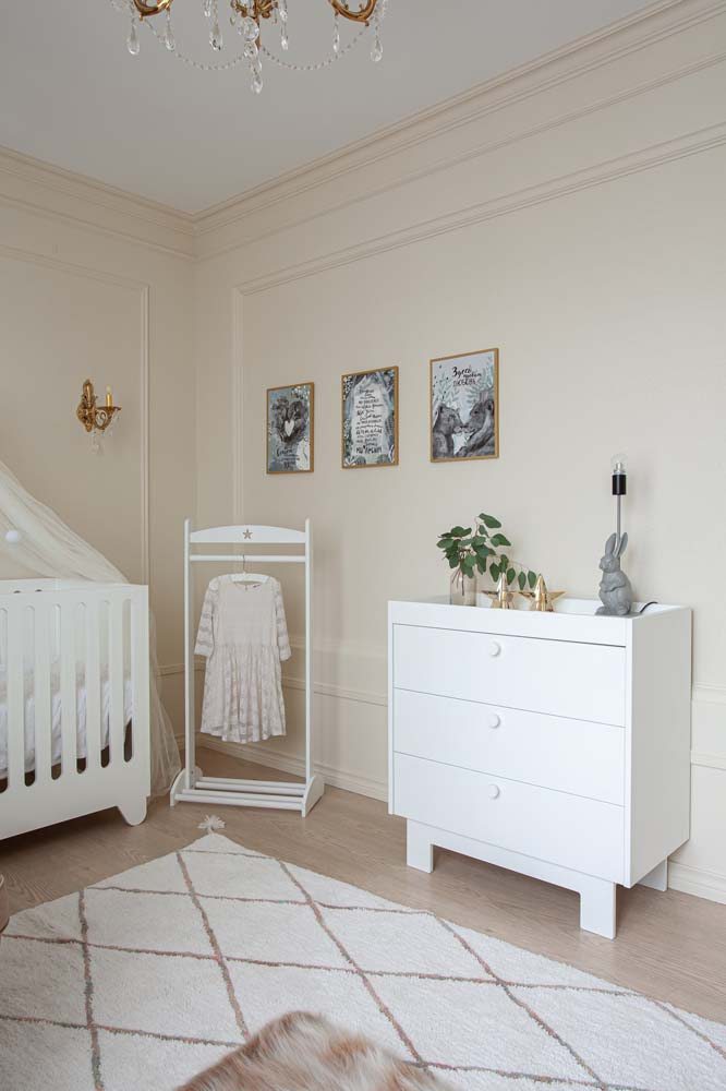 Cômoda branca simples com pequenos objetos decorativos que agregam na decoração do quarto infantil.