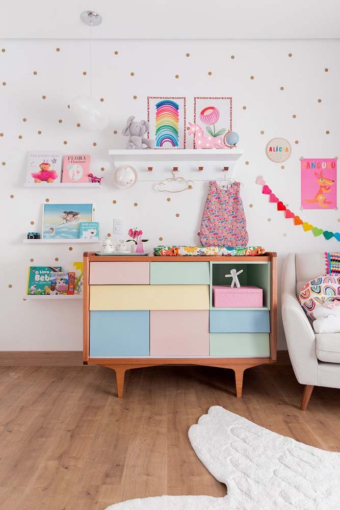 Um quarto infantil feminino repleto de candy colors, inclusive nas gavetas e nichos da cômoda.