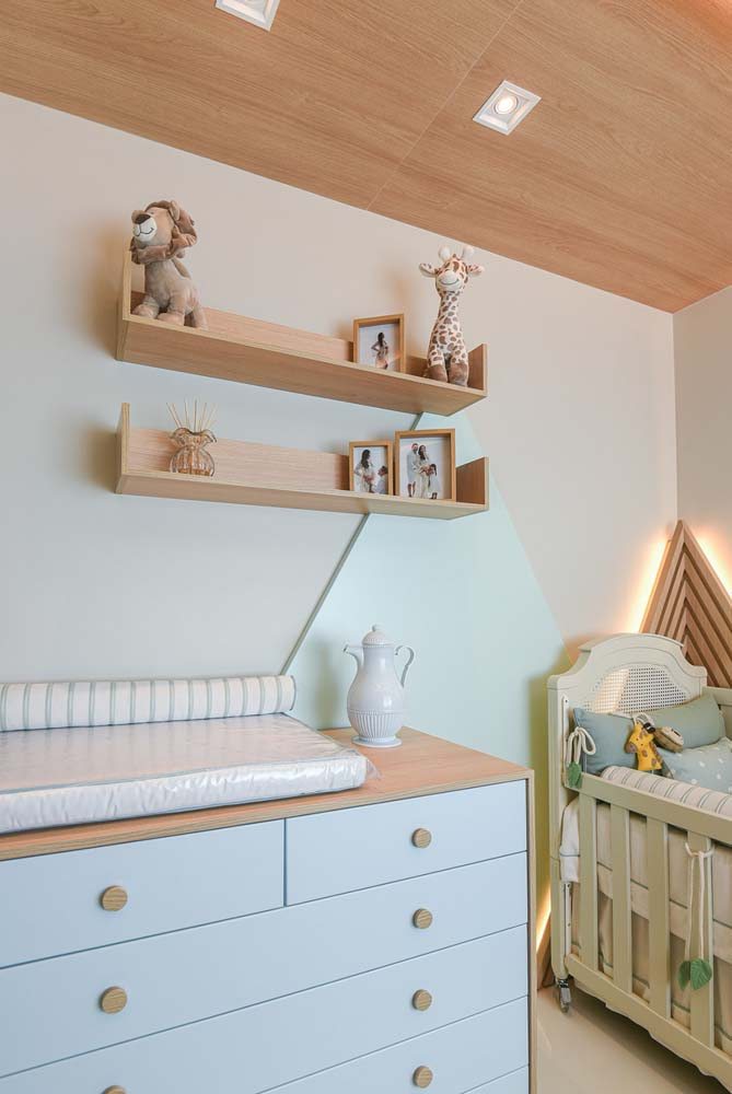 Cômoda minimalista azul bebê em quarto de bebe compacto, além de ampla presença da madeira clara.