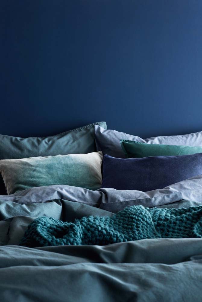 Um mar de azul para despertar a criatividade: diversos tons da cor, desde a pintura da parede até a roupa de cama.