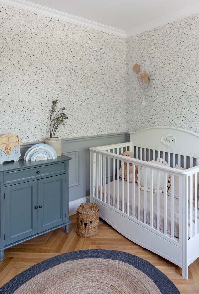Cômoda infantil com pintura azul em quarto de bebê com cores neutras.