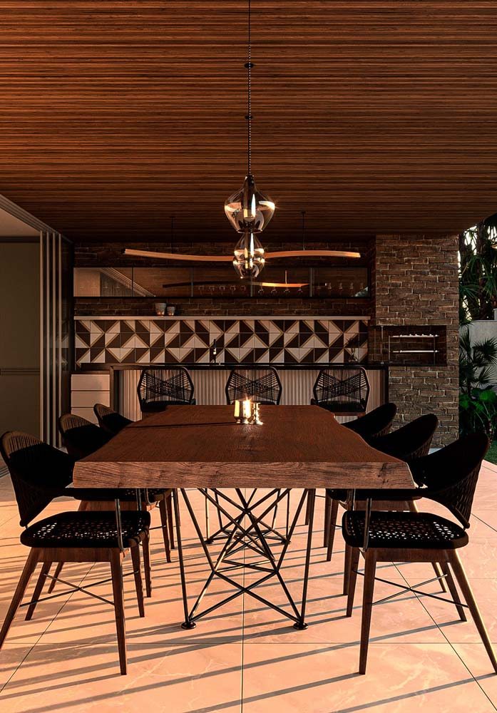 Área gourmet rústica aberta com mesa e outros detalhes em madeira.